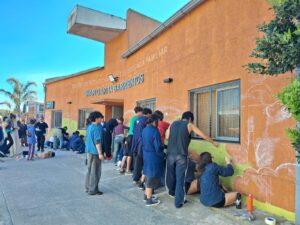 Estudiantes pintando el mural en la fachada del CPI San Cayetano