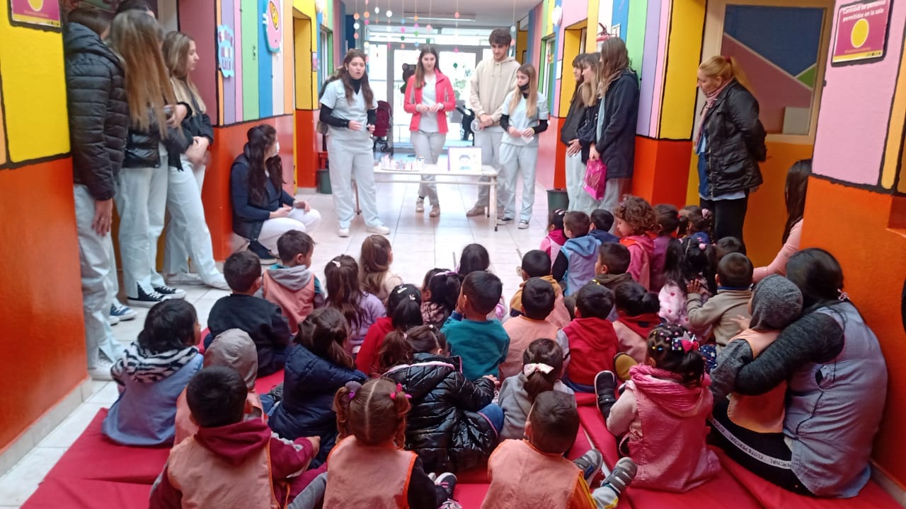 Grupo de niños y niñas sentados de espalda mirando a las maestras